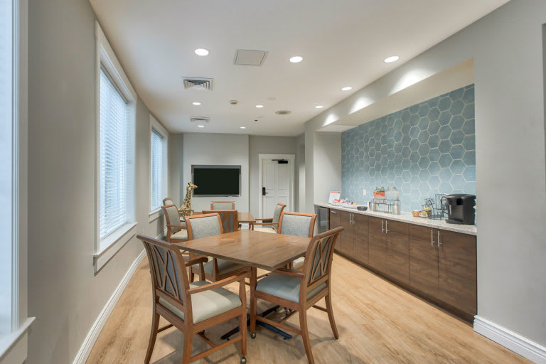 A modern meeting room with a large conference table, comfortable chairs, and ample natural light.