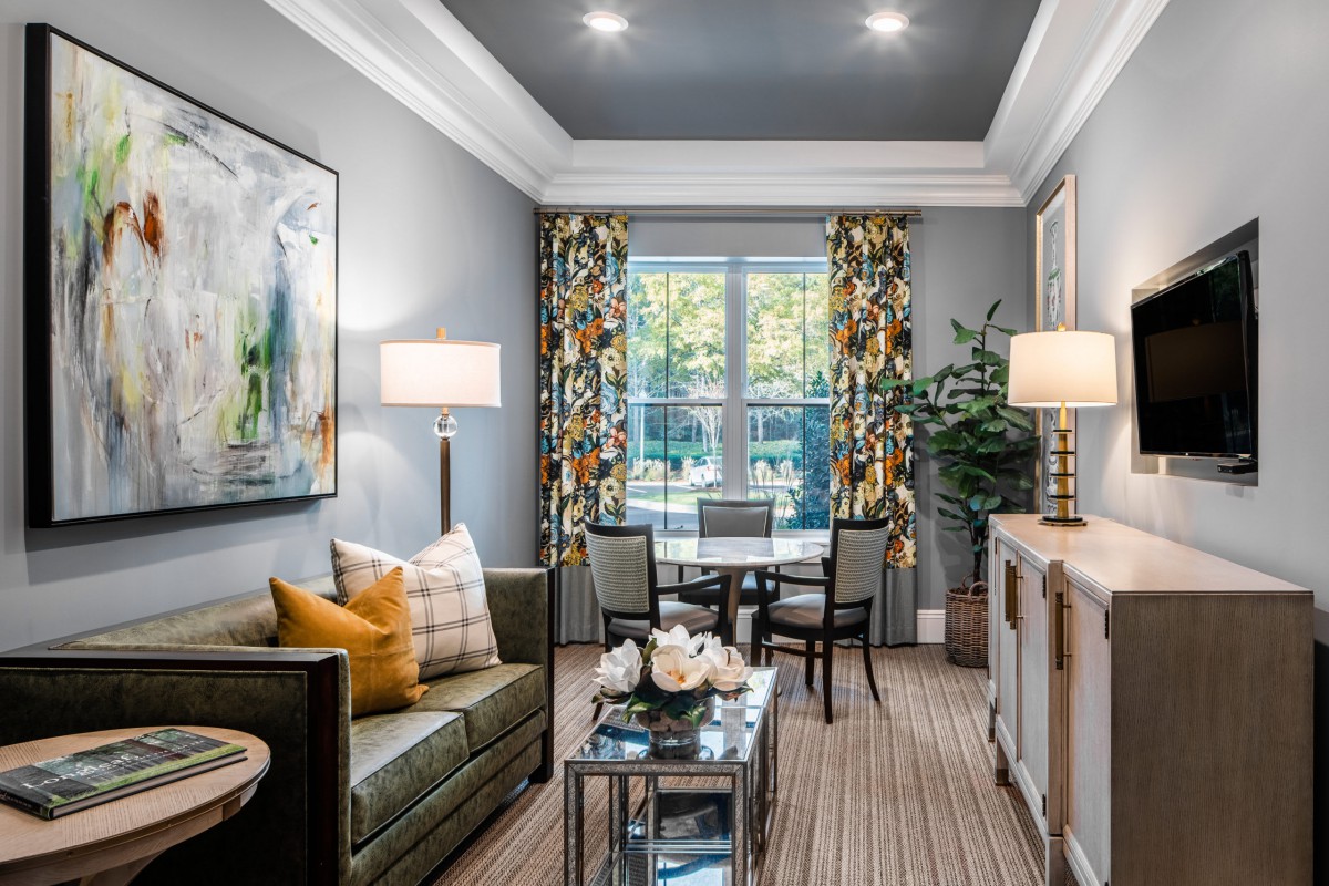A stylishly decorated living room featuring a comfortable sofa, modern artwork, and elegant lighting.