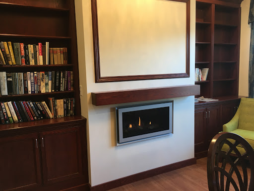 A modern living room featuring a stylish fireplace and built-in bookshelves.