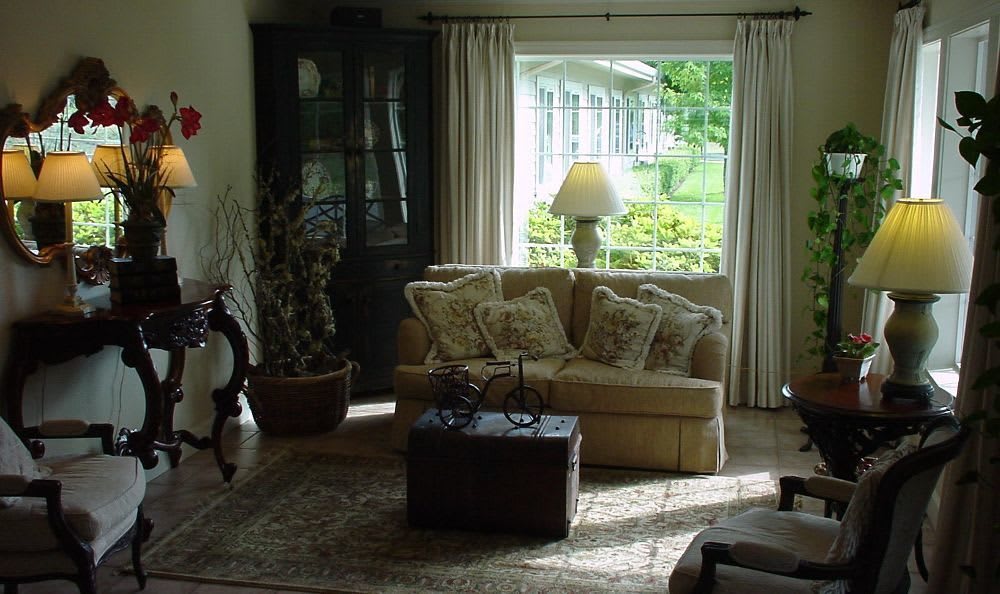 A cozy living room with a sofa and large window letting in natural light.