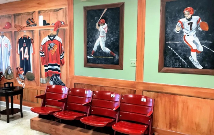 A collection of sports memorabilia featuring a hockey jersey, a baseball player painting, and vintage stadium seats.