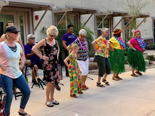 Participants enjoying a lively Hawaiian-themed dance in a joyful outdoor setting.