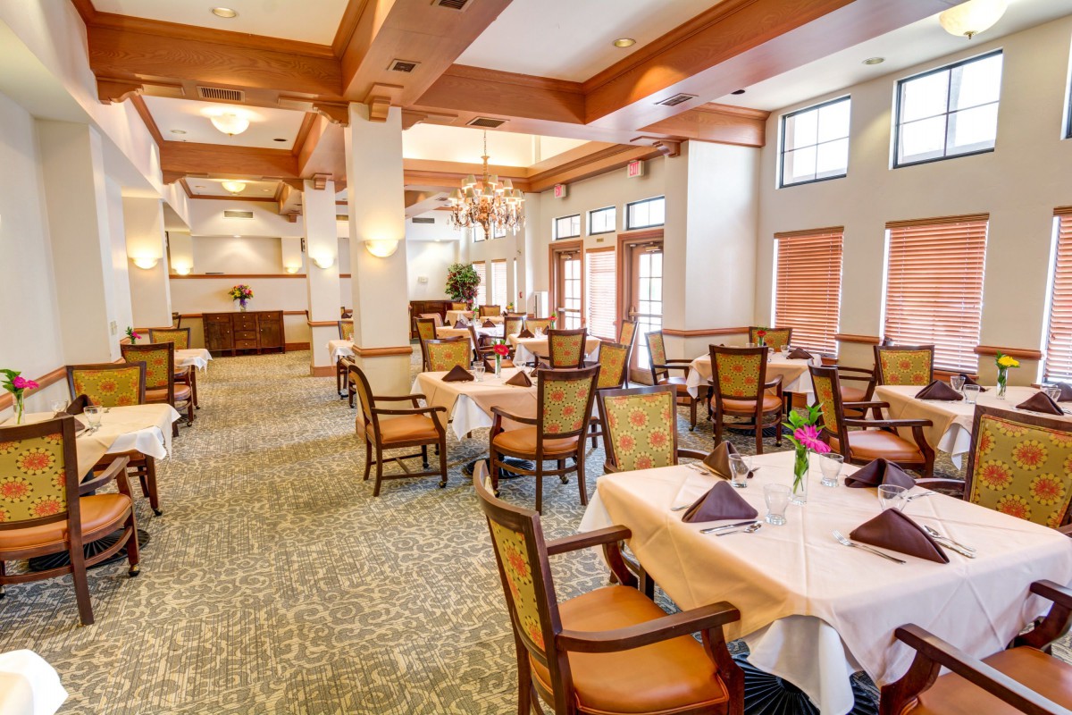 An elegant restaurant dining room with neatly arranged tables and chairs.