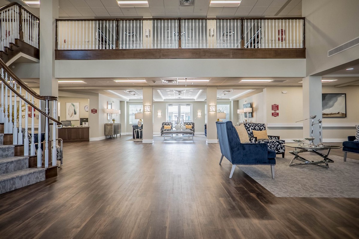 A spacious and modern lobby with wood flooring and comfortable seating areas.