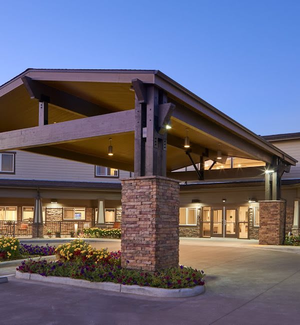 A modern building entrance with a covered walkway during the evening.
