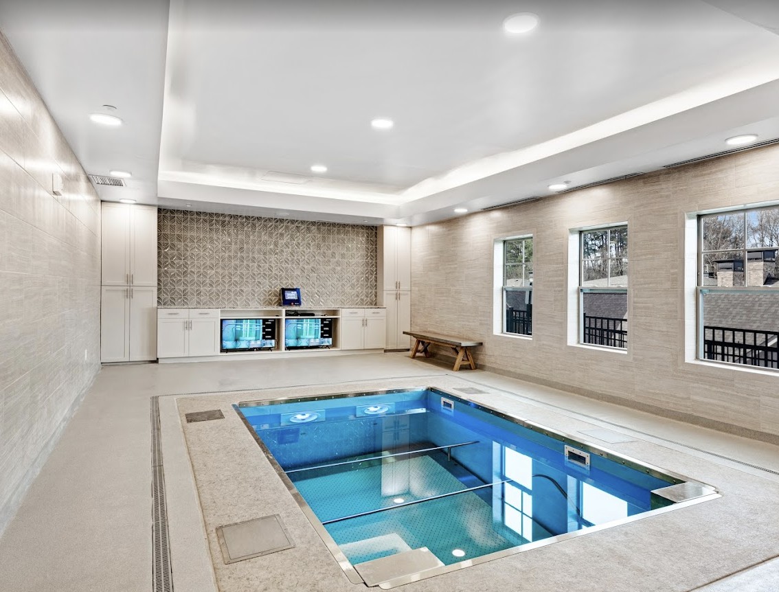 A modern and luxurious indoor swimming pool with sleek, contemporary design elements.