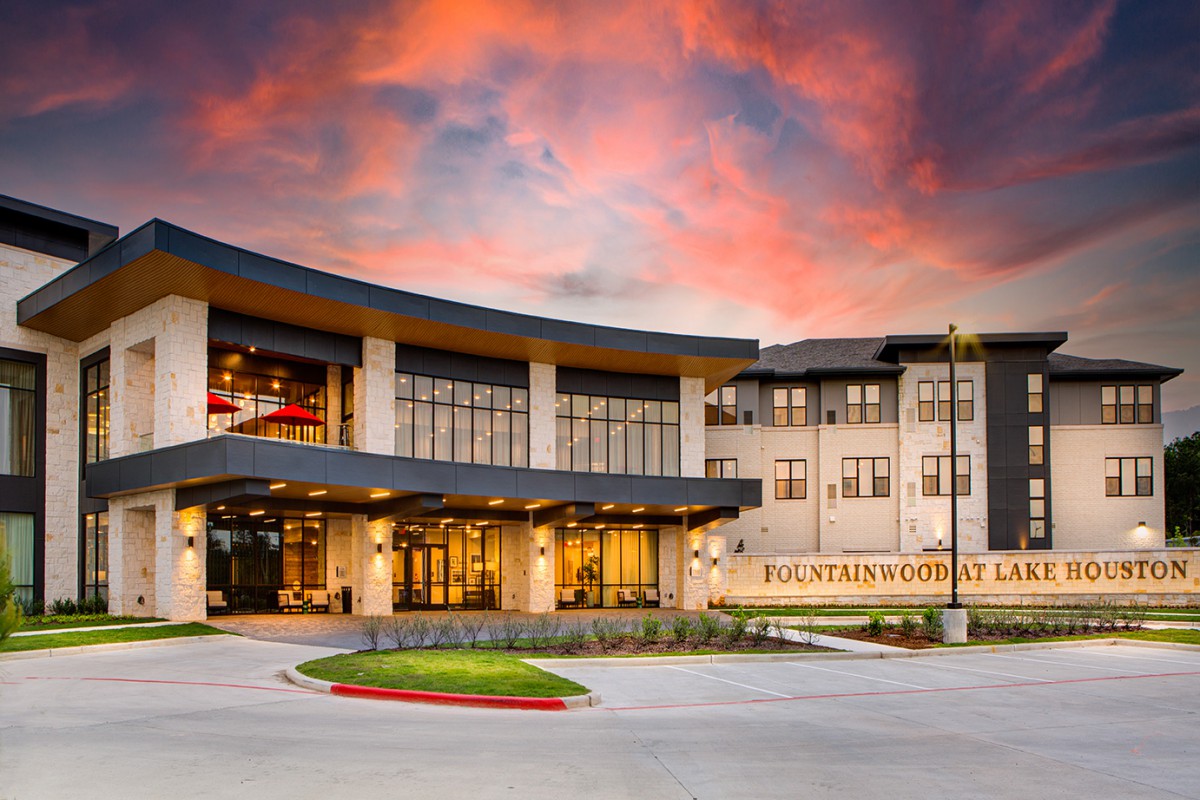 A modern building with a striking entrance set against a vibrant sunset.