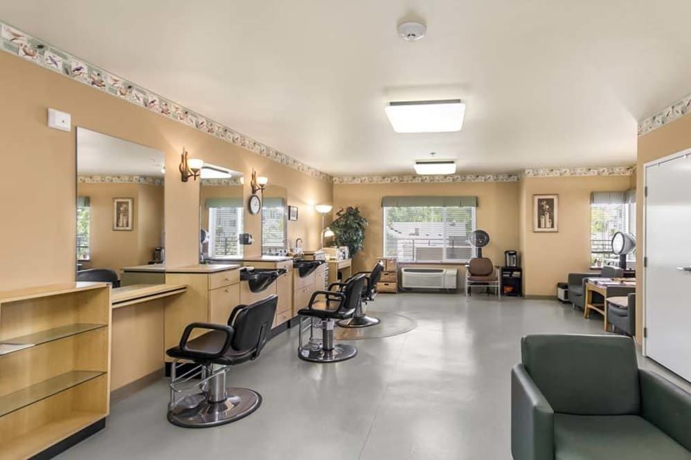A well-lit hair salon with multiple styling stations and a cozy waiting area.