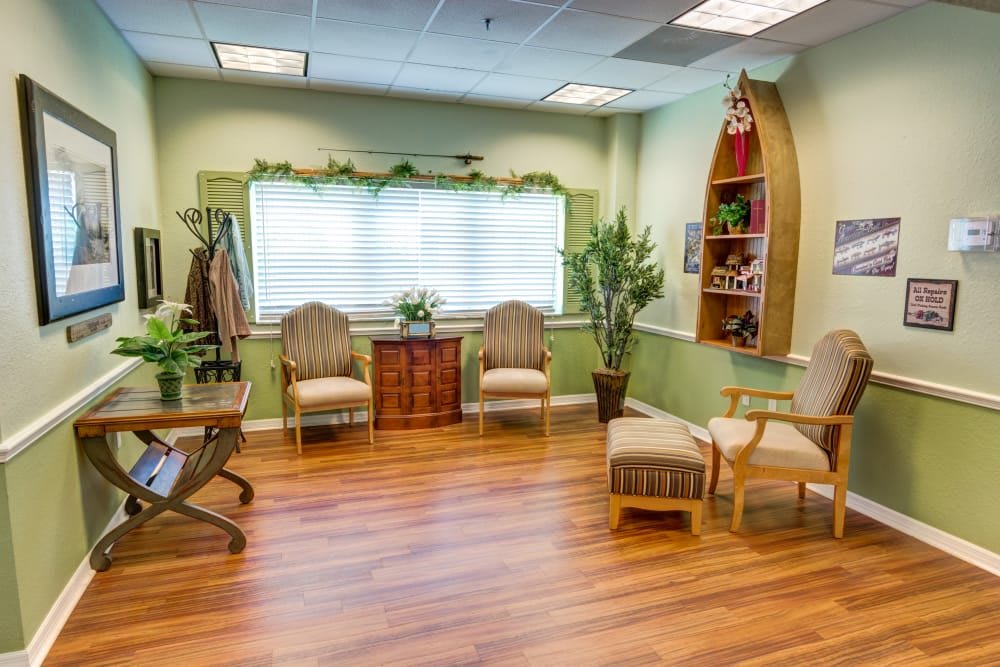 A cozy waiting room with wooden flooring and comfortable seating.