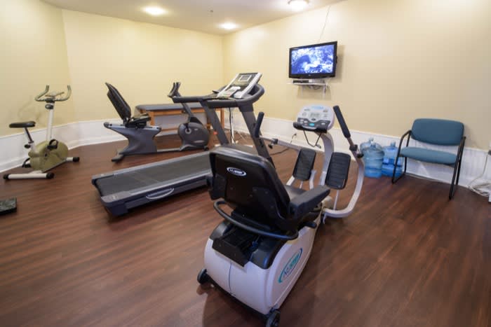 A small gym with exercise machines including a treadmill and stationary bike.