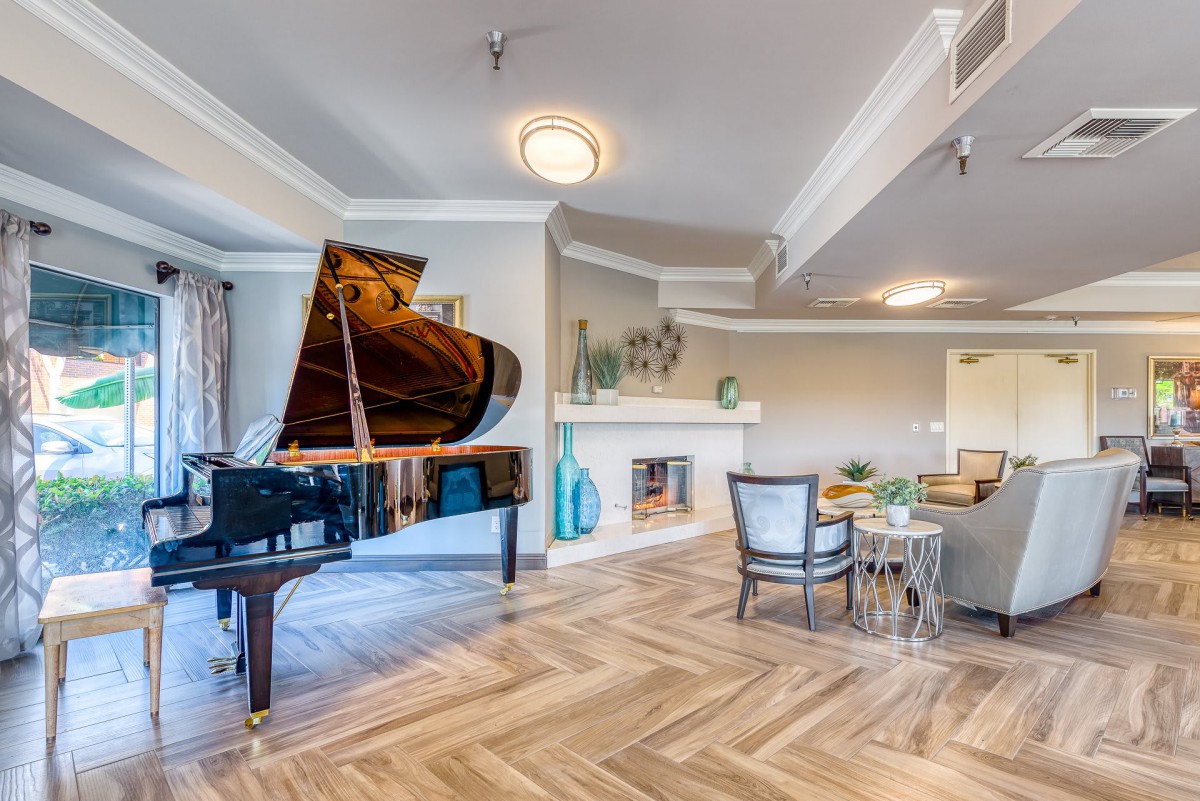 A modern living room featuring a grand piano, stylish furniture, and a cozy fireplace.