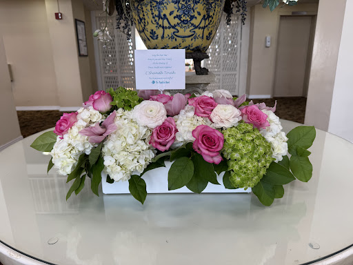 A beautiful floral arrangement featuring roses, hydrangeas, and greenery, perfect for adding a touch of elegance to any space.