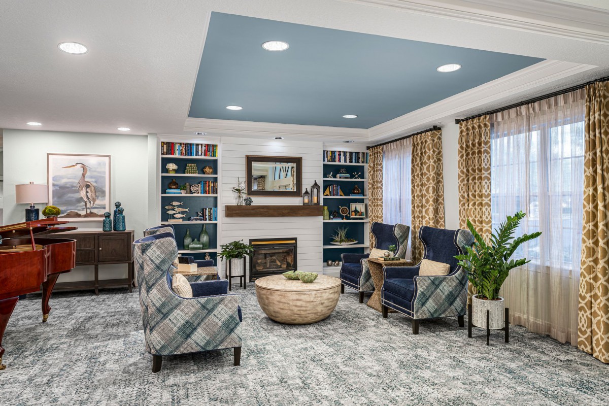 A cozy living room with comfortable seating, a fireplace, and decorative bookshelves.