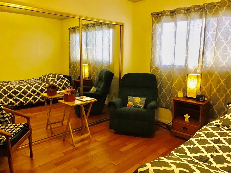 Cozy bedroom with a recliner chair, mirrored closet, and warm lighting.