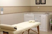 A serene massage room with a therapy table and calming decor.
