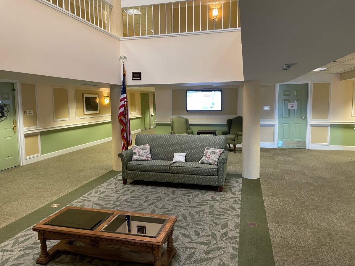 A lobby area with a sofa, American flag, and seating arrangement.