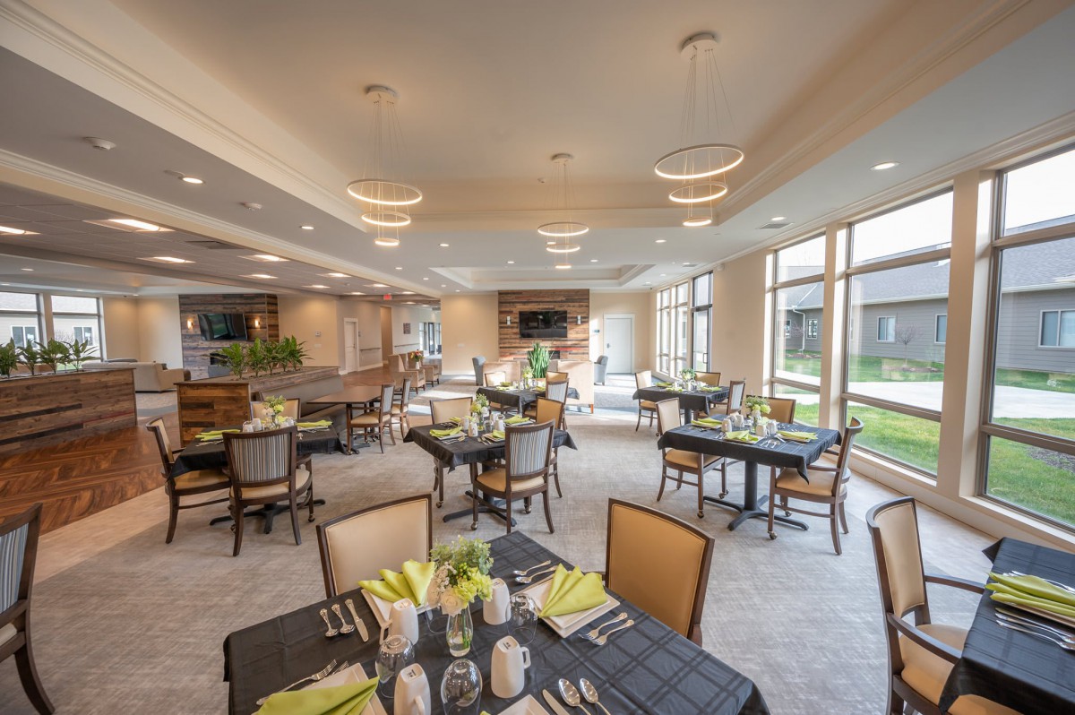 A well-lit dining room with elegantly set tables and comfortable seating.