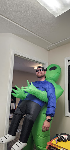 A playful moment captured with a person in an inflatable alien costume.