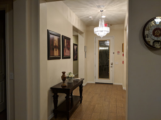 A well-lit hallway featuring decorative artwork and elegant furnishings.