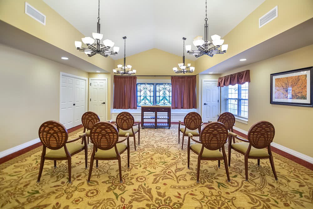 A well-lit meeting room with elegant chairs and ornate carpet.