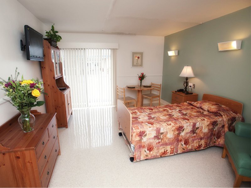 A cozy hotel room with floral bedding and warm furnishings.