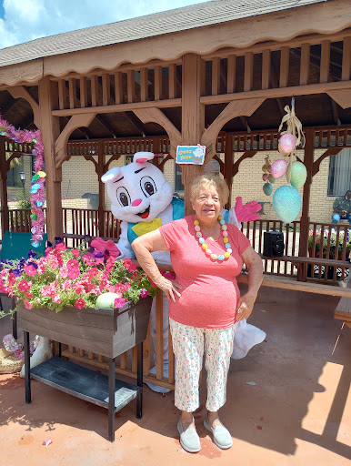 A cheerful moment in the garden with a vibrant display of flowers and a fun mascot.