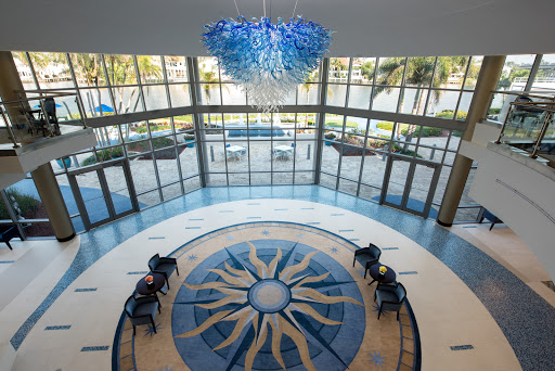 A spacious lobby featuring a unique chandelier and elegant floor design, illuminated by natural light.