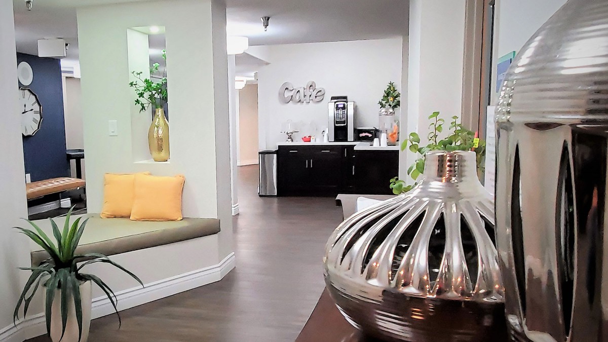 A modern office interior with a cozy waiting area and a coffee station.