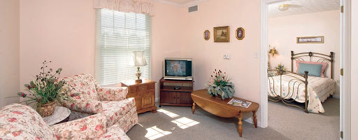 A cozy living room featuring floral-patterned furniture and a vintage television.