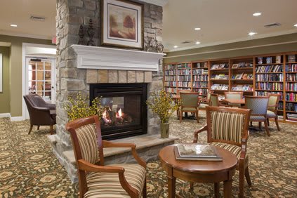 A cozy library interior with a fireplace and comfortable seating.