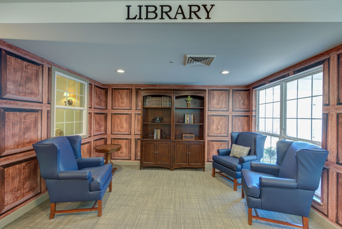 A cozy library space with comfortable seating and wooden bookshelves.
