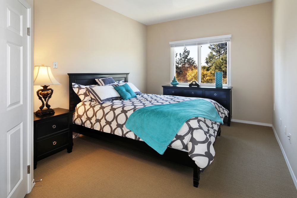 A cozy bedroom with a patterned bedspread and turquoise accents.