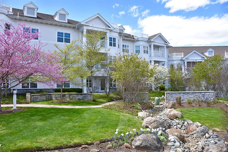 A well-maintained apartment building with lush landscaping and blooming trees in spring.