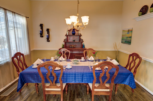 A beautifully arranged dining room featuring a blue tablecloth and wooden furniture.