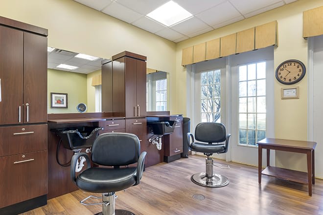 A modern hair salon with styling chairs and large mirrors.