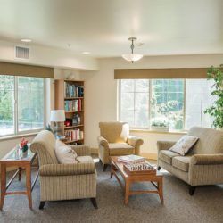 A cozy living room with comfortable armchairs and a large window.