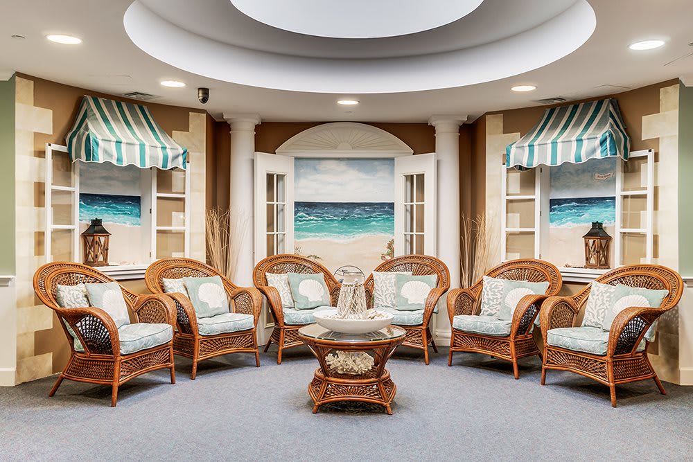 A cozy lounge area with wicker furniture and a beach-themed decor.