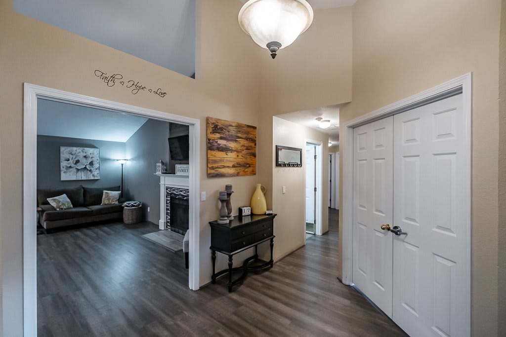 A cozy hallway leading into a living room with modern decor and flooring.