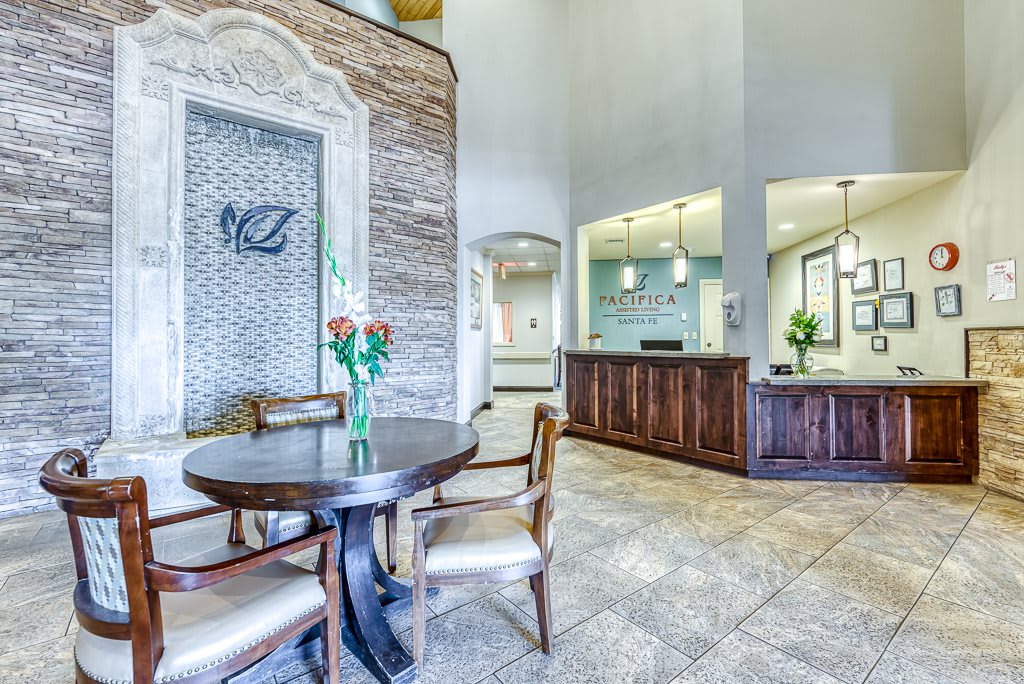 A bright and welcoming lobby area with a table, chairs, and a reception desk.