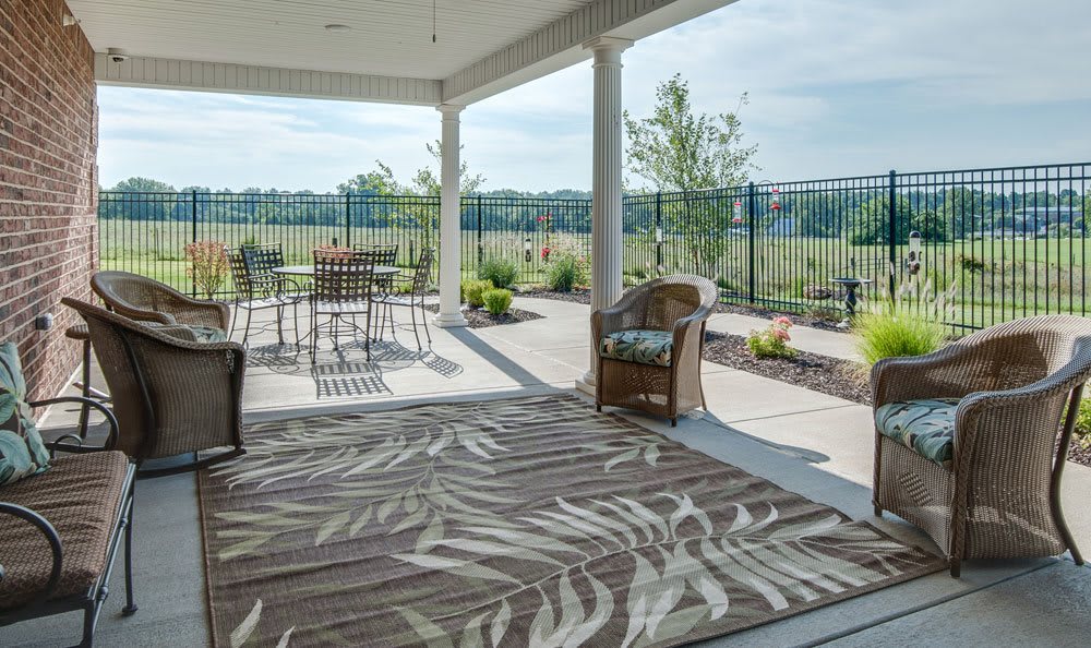 A spacious outdoor patio with seating and a scenic garden view.