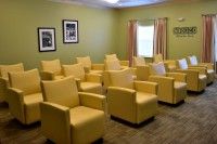 A room with yellow chairs arranged in rows, suitable for meetings or presentations.