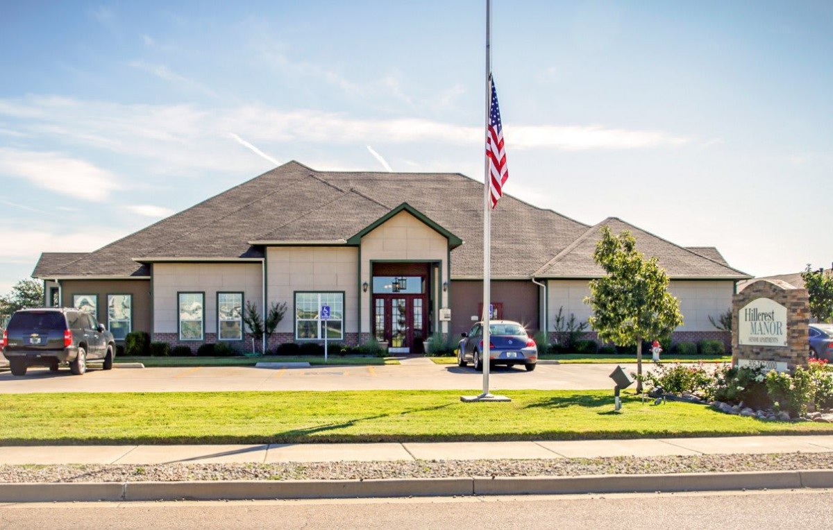 A suburban house with a manicured lawn and an American flag in front.