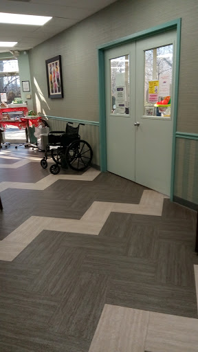 A view of a healthcare facility's waiting area featuring a wheelchair and distinctive floor pattern.
