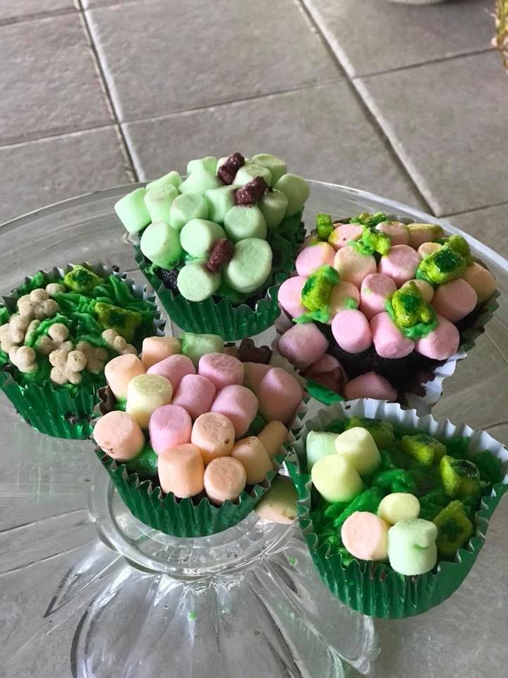 Colorful marshmallow-topped cupcakes on a glass plate.