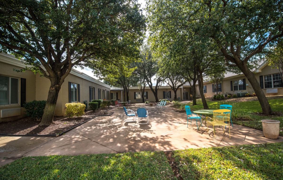 A serene courtyard with outdoor seating and lush greenery.