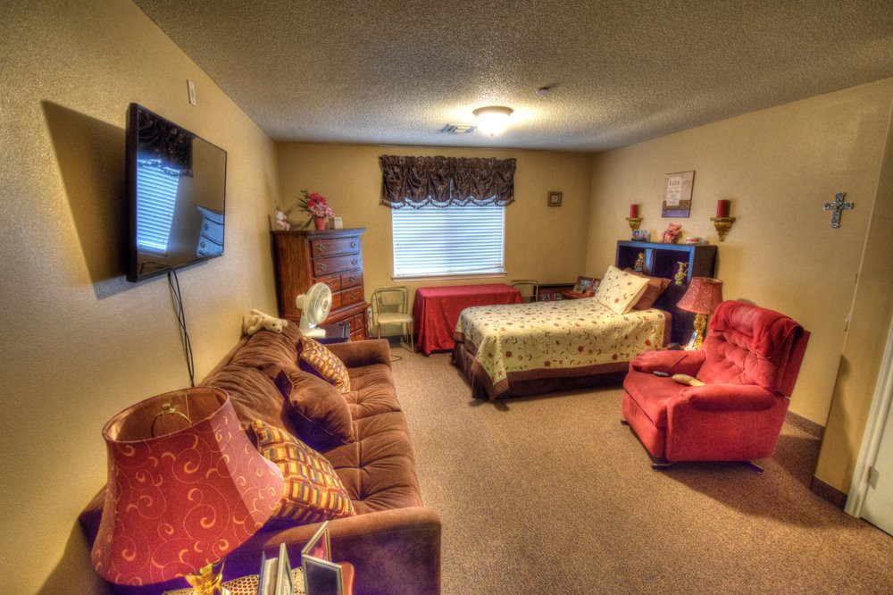 A cozy bedroom with a bed, sofa, and television.