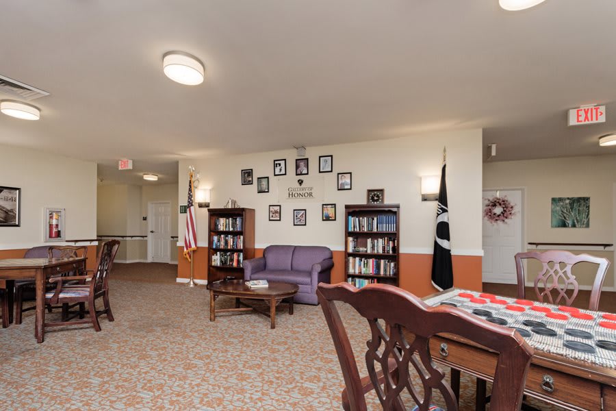 A cozy common area featuring bookshelves, comfortable seating, and various decorations.