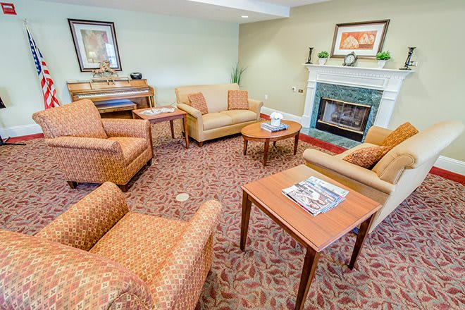 A cozy living room with sofas, armchairs, and a fireplace.