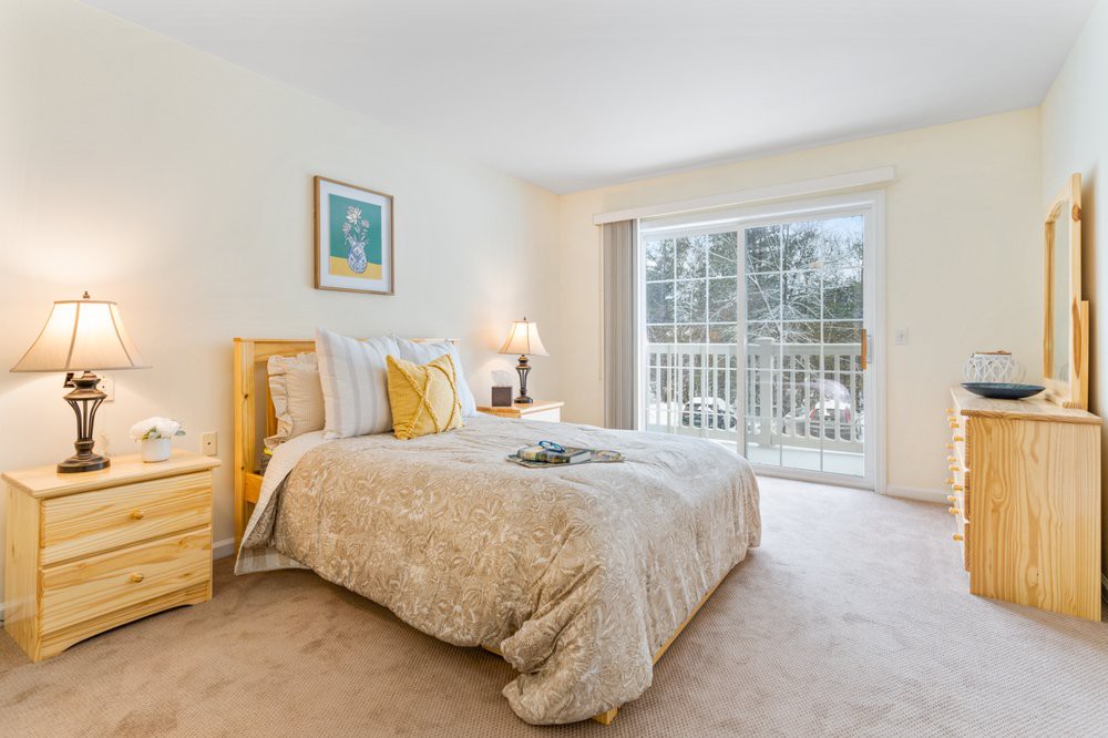 A cozy bedroom with modern decor and a large window allowing natural light.