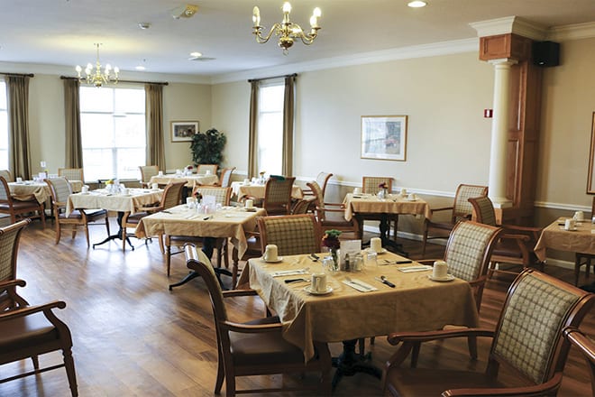 An elegant dining room set with tables and chairs, ready for guests.